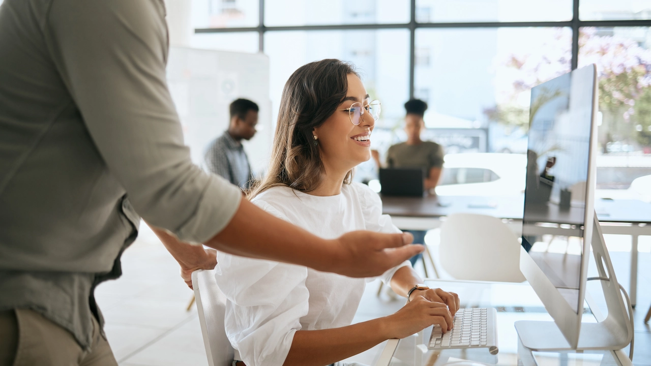 man training woman at computer desk